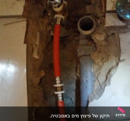 צינור אדום ושסתום בתוך קיר פתוח